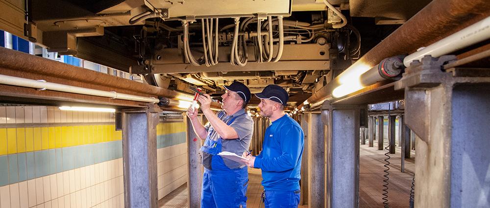 Thomas Brückner und Christian Pusch kontrollieren die Fahrwerke der Straßenbahn