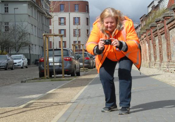 Ina Holtz hält mit der Kamera fest, wo ein Gehweg nicht richtig verfugt wurde