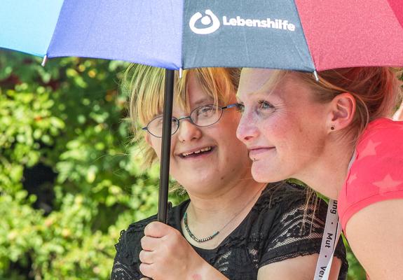 René freut sich auf den Sommer, dann steht bei seinem Außenarbeitsplatz am Kinderzentrum Rasenmähen auf dem Programm. Peggy arbeitet in der Tagesgruppe und kommuniziert mit ihrem Talker vom Rollstuhl aus.