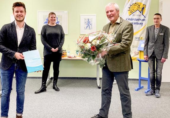 Stephan Bauerdick (l.) von PubliCare übergibt den Spendenscheck an Dr. Tilman Köhler vom SPZ. Hinten links: Kristina Timmermann, Geschäftsführerin des Kinderzentrum Mecklenburg; rechts: Jörg Gröpler