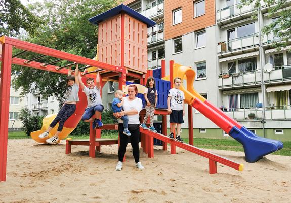 Der neue Spielplatz im Innenhof der Anne-Frank-Straße lädt seit Kurzem zum Toben und Spaß haben ein. Alles ist bunt und verlockend. WGS- Mieterin Anke Kalmbach ist mit ihren Kindern und Enkelkindern mittendrin.