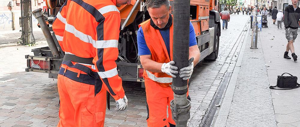 Die Abwassertechniker Julius Lawrenz und Heiko Meytzeich reinigen Kastenrinnen und Einläufe in der Altstadt