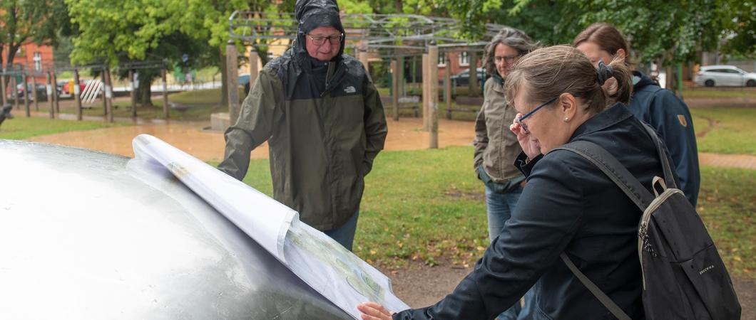 Katarina Dominka vom SDS (rechts) begutachtet die Entwürfe des Planungsbüros für den Wohngebietspark Bleicherufer