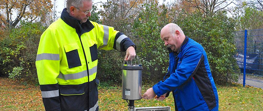 Jörg Hahn und Dirk Haschke (r.) von der WAG prüfen den Regenmesser in der Mecklenburgstraße