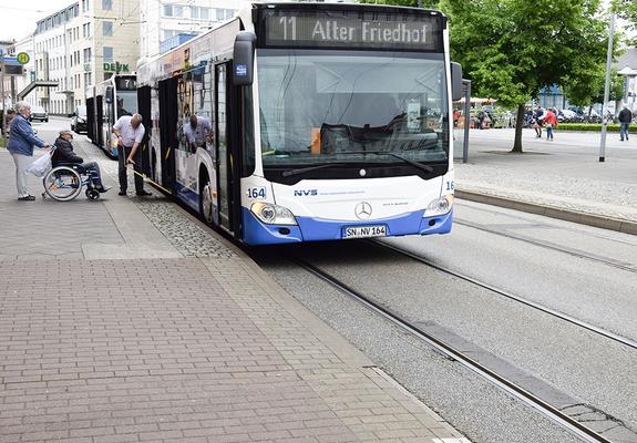 Ein Bus steht mit eingeschaltetem Warnblinklicht an einer Haltestelle am Straßenrand. Nachfolgende Autofahrer wissen in dieser Situation oft nicht, wie sie reagieren sollen – warten oder vorbeifahren?