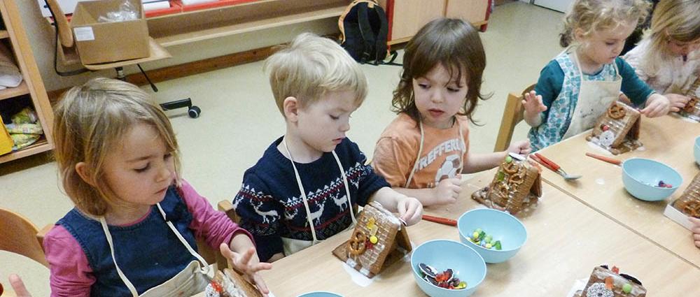 Lieselotte, Domenic, Hans und Mia Ella packen in der Kita Rappelkiste Päckchen für andere Kinder