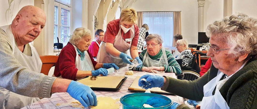 „Alle Jahre wieder“ ruft Karin Ristau vom Sozialen Dienst in den Speisesaal und eröffnet damit die Weihnachtsbäckerei mit den Bewohnern vom Netzwerk für Menschen. Im Hintergrund läuft stimmungsvolle Musik.