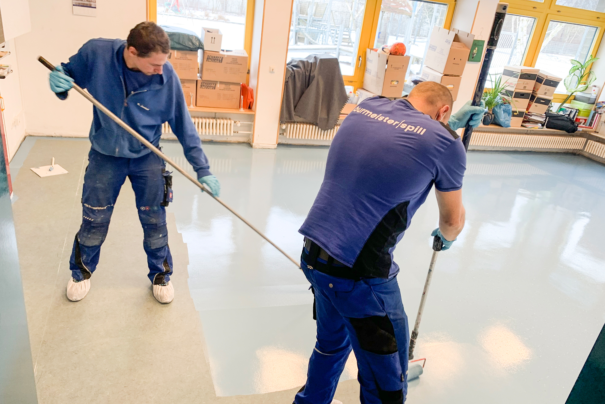 V.l.: Ronny Petteron und Sven Jenkel (Burmeister & Spill GmbH ) geben dem fertig beschichteten Boden den letzten Schliff